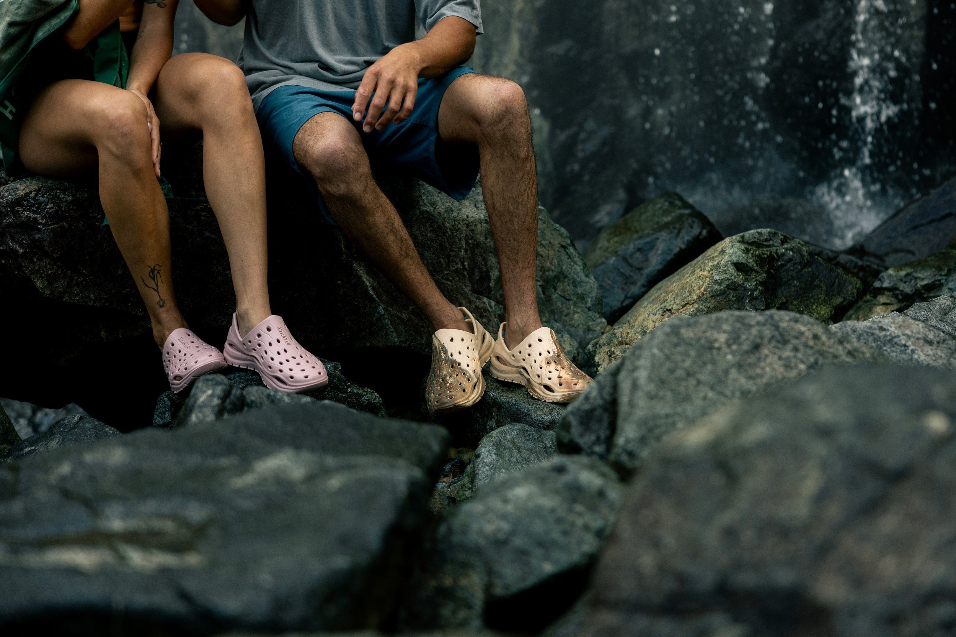 Two people sitting on rocks wearing sandals