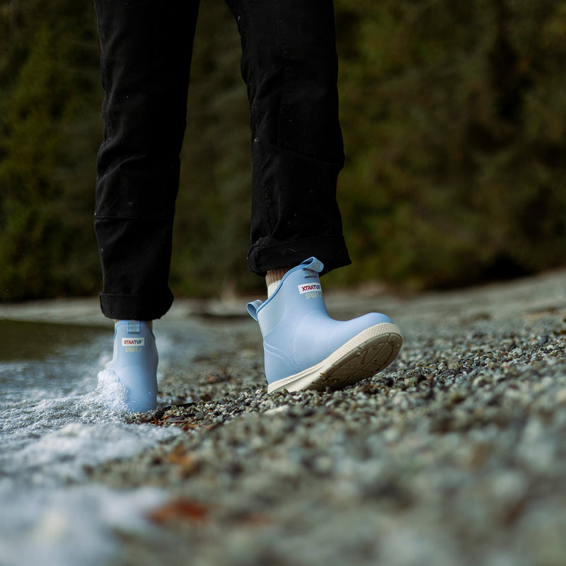 Person wearing light blue boots with a blurred natural background