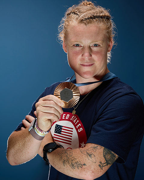 Person holding a medal with a blue background