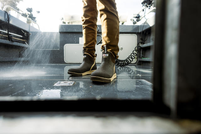Person wearing brown boots stepping onto a vehicle with a blurred background