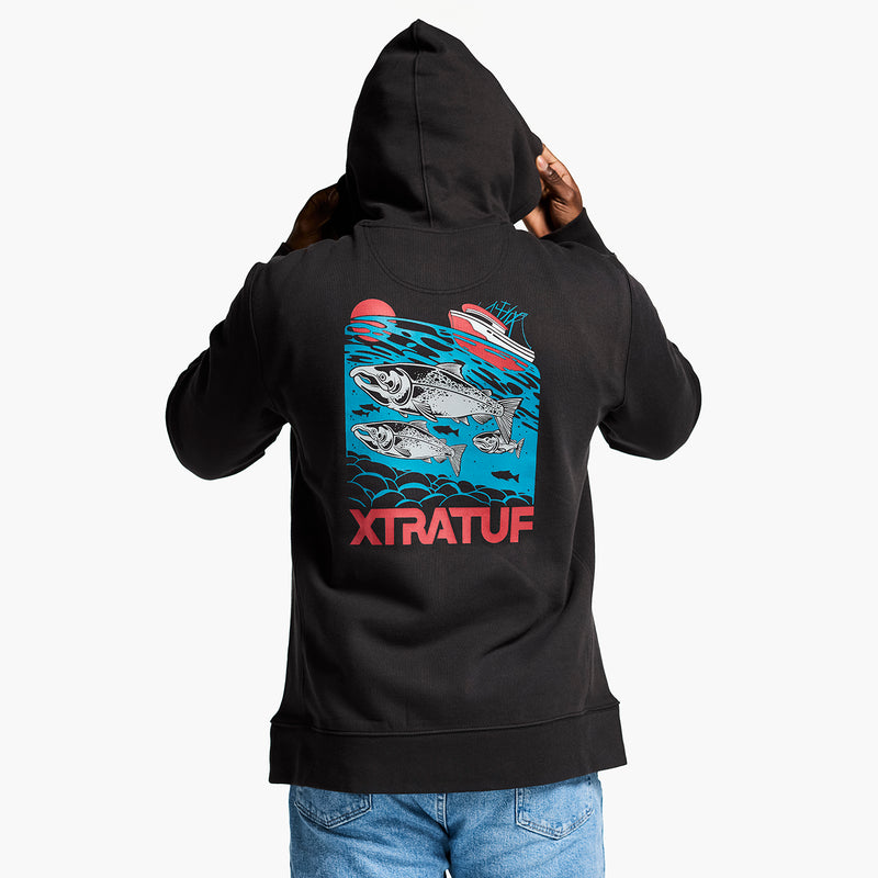 Person wearing a black hoodie with XTRATUF graphic on the back