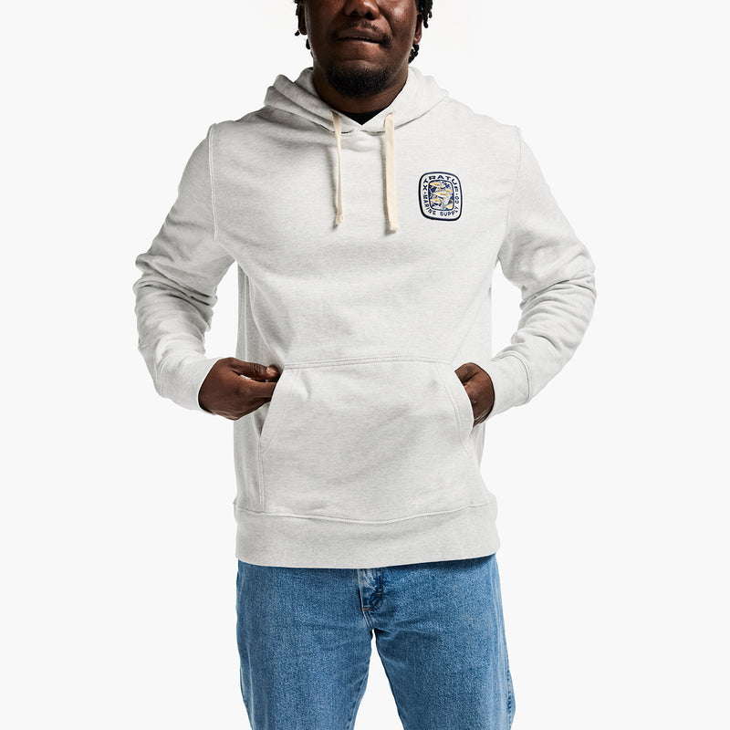 Person wearing a white hoodie with a logo on a white background
