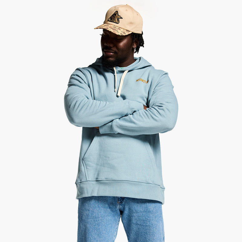 Person wearing a light blue hoodie and beige cap on a white background