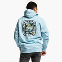 Person wearing a light blue hoodie with a logo on the back, standing against a white background