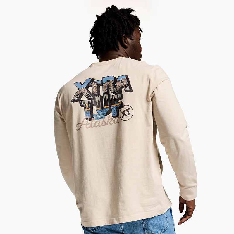Person wearing a beige long-sleeve shirt with 'Xtra Tuff' logo on the back, standing against a white background.
