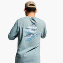 Man wearing a light blue long-sleeve shirt with a fish graphic on the back, standing against a white background.