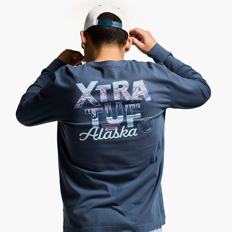 Person wearing a blue long-sleeve shirt with 'Xtra Tuf Alaska' text on the back.