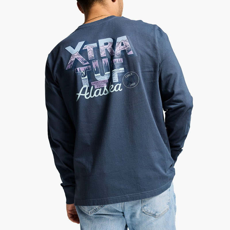 Person wearing a navy long-sleeve shirt with 'Xtra Tuf Alaska' text on the back, on a white background
