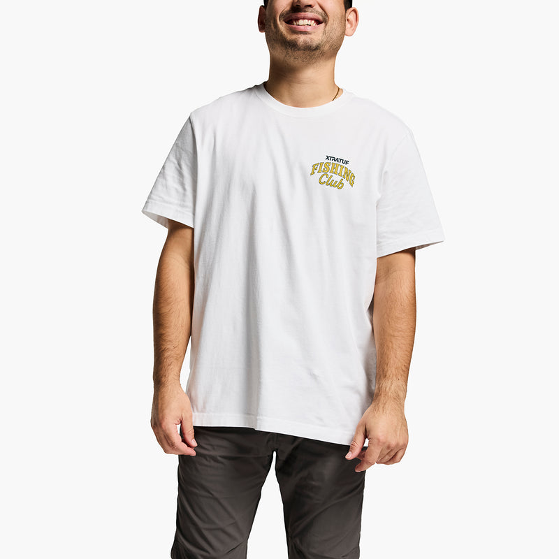 Man wearing a XTRATUF white t-shirt with text and gray pants on a white background